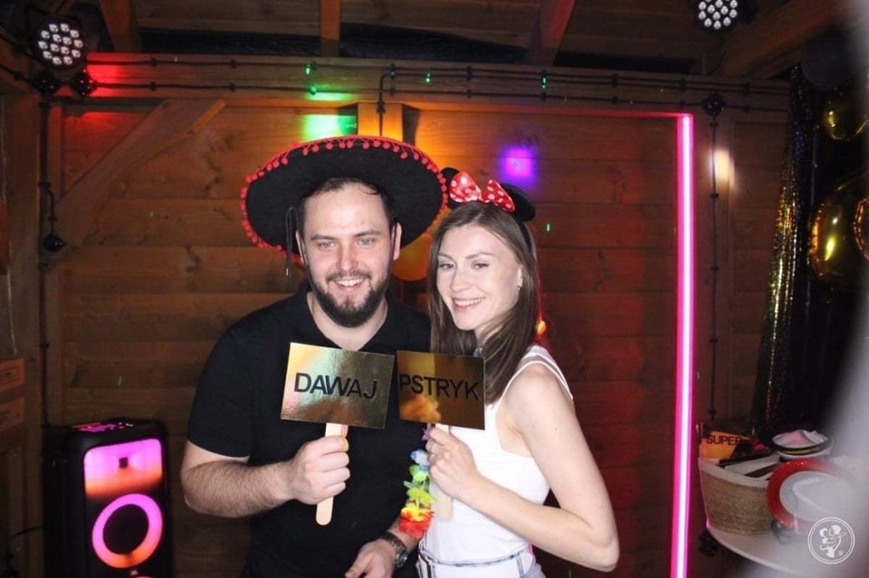 Goście przy fotobudce z gadżetami — zabawa z tabliczkami „Dawaj pstryk” na imprezie